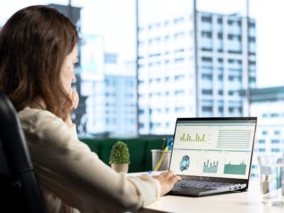 Analyst monitoring a web traffic dashboard on a laptop overlooking a city