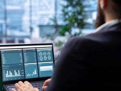 Businessman reviewing a multi-panel analytics dashboard with traffic sources on a laptop